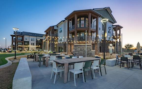 A patio with a grill and seating area.