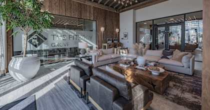 A modern living room with a large tree and a sign that says "The Fitzroy Grove".