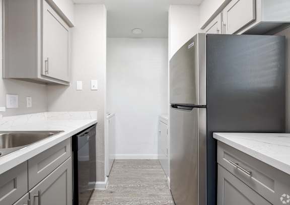 A kitchen with a white counter top and grey cabinets at Brook Meadow Village Apartments , Austin, TX, 78758