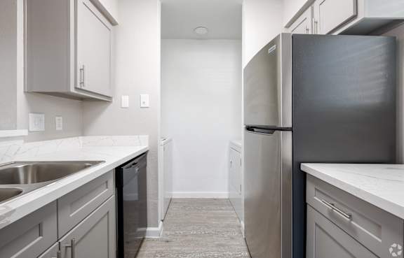 A kitchen with white cabinets and a black dishwasher. at Brook Meadow Village Apartments , Austin, TX, 78758