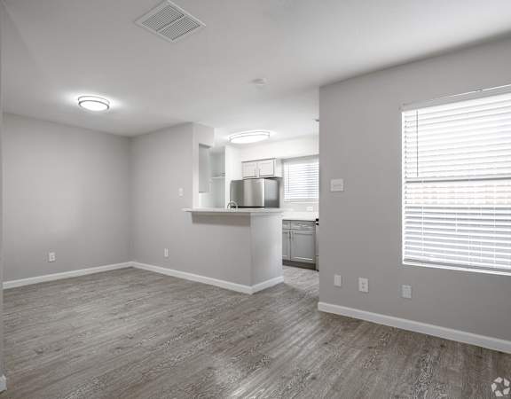 A kitchen area with a refrigerator, sink, and cabinets.