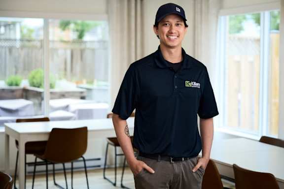 An employee in a Killam shirt and hat.