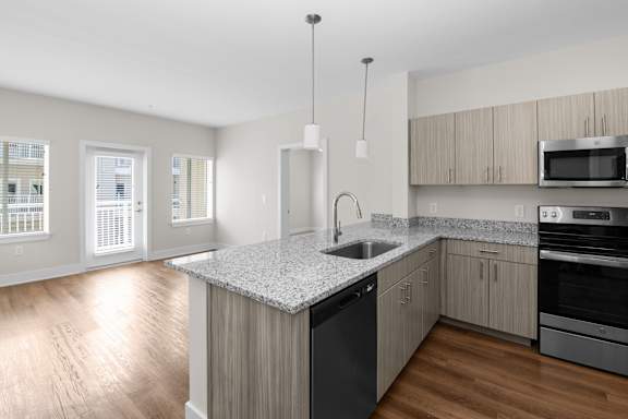A kitchen with a granite countertop and stainless steel appliances.