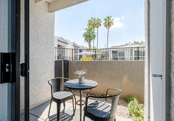A patio with a table and two chairs.