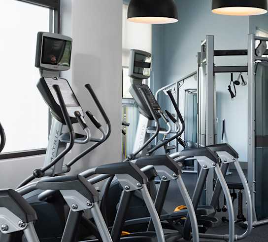 A row of treadmills are lined up in a gym.