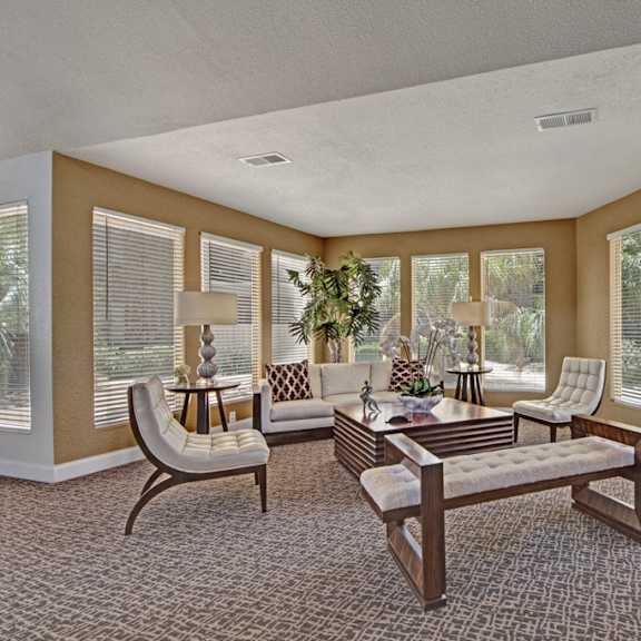 The common room at Northridge Court with a couch, coffee tables, chairs. 