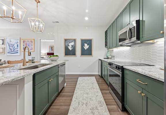 A kitchen with green cabinets and a marble countertop. at Maison Apartments, Westerville