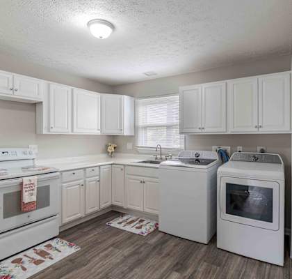 a white kitchen with white appliances and white cabinets