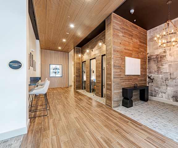 A hallway with a wooden floor and a stone wall at The Edison Lofts Apartments, Raleigh, NC, 27601