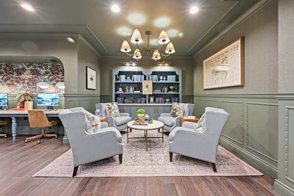 A blue couch sits in a living room with a wooden table and chairs.