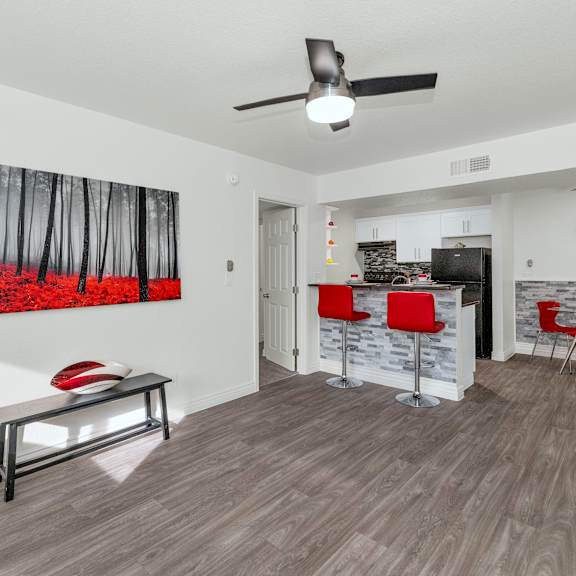 A room with a ceiling fan and a painting of a forest on the wall at Urban WalkApartments on 6th Avenue, Arizona 85016