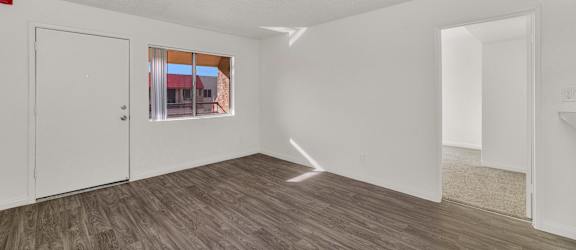 A room with a wooden floor and white walls at Urban WalkApartments on 6th Avenue, Phoenix 85016
