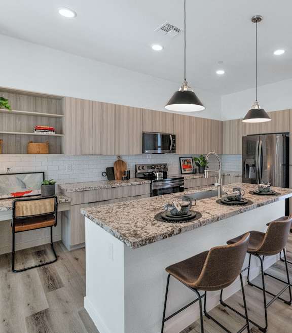 a kitchen with a large counter top next to a stove top oven  at Marketside Villas at Verrado, Buckeye, AZ 85396