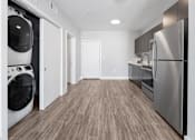Thumbnail 7 of 9 - A modern laundry room with a washer and dryer.
