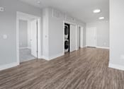 Thumbnail 9 of 9 - A room with a wooden floor and white walls.