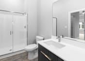 Thumbnail 6 of 10 - A white bathroom with a toilet, sink, and shower.