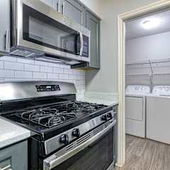 a kitchen with a stove and microwave and a washer and dryer