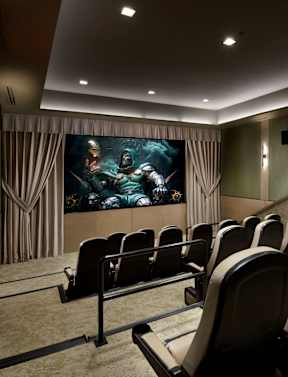 A row of black chairs are set up in front of a large screen.
