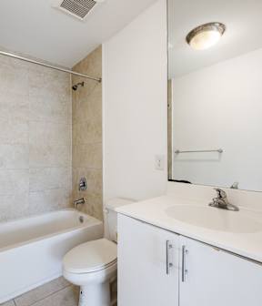 A white bathroom with a toilet, sink, and bathtub.