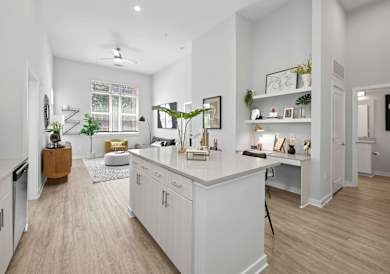 an open kitchen and living room with a bar and stools