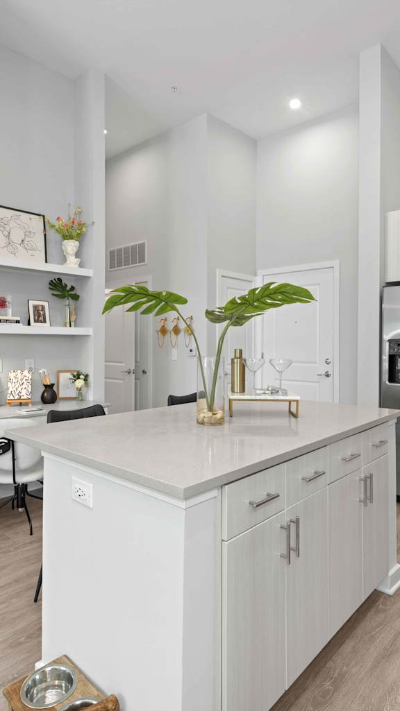 a white kitchen with a large island in the middle