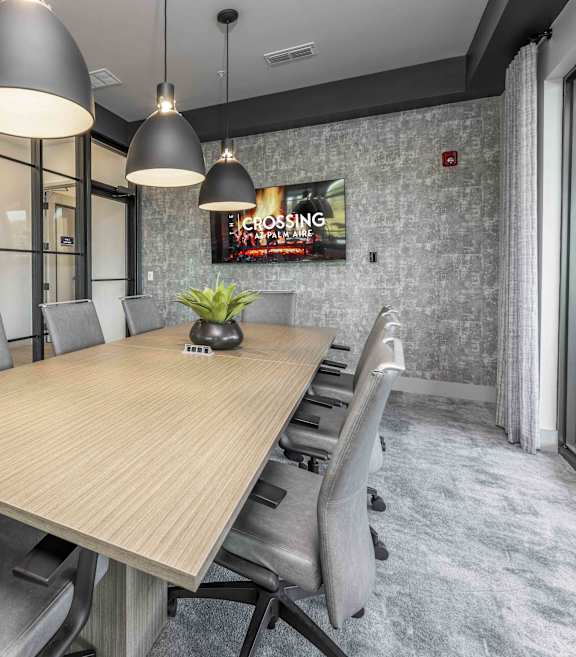 A conference room with a long table and chairs.