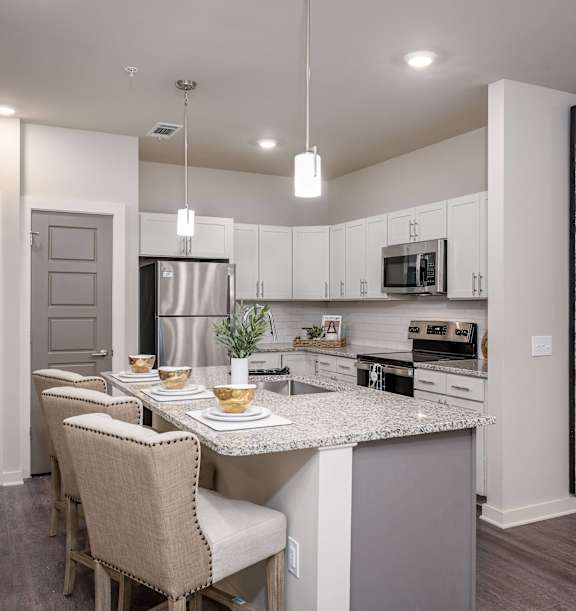 an open kitchen and dining area with a marble counter top