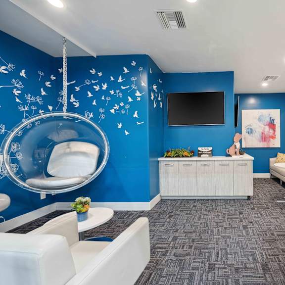 A room with a blue wall and a white chair.
