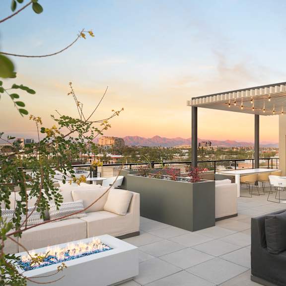 A modern outdoor living space with a fire pit and comfortable seating.