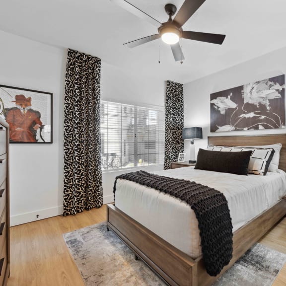 a bedroom with a large bed and a ceiling fan