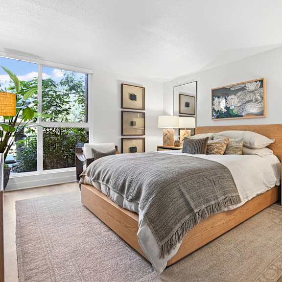 A bedroom with a large bed, a dresser, and a mirror.