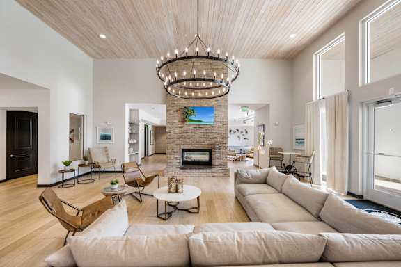 A modern living room with a fireplace and a chandelier.