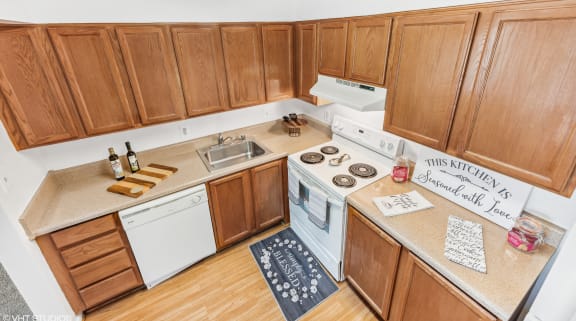 an aerial view of a kitchen with wooden cabinets and white appliances