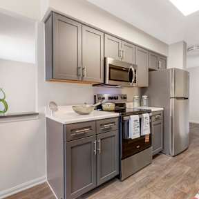 A kitchen with dark brown cabinets and stainless steel appliances