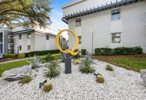 a yard with a large yellow sculpture in front of a building