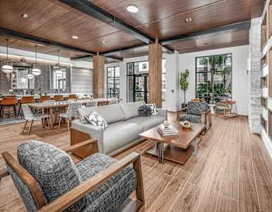 a living room with couches and chairs and a dining room with tables at The Haven at Lake Britt Apartments, Winter Garden, FL 34787