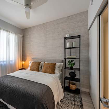 A bedroom with a bed, a table, and a chair.