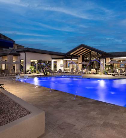 A large outdoor swimming pool with a blue light reflection at the bottom.