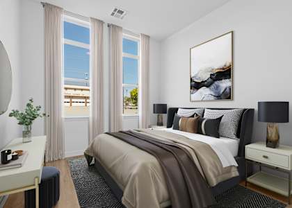 A bedroom with a large bed and a painting on the wall.