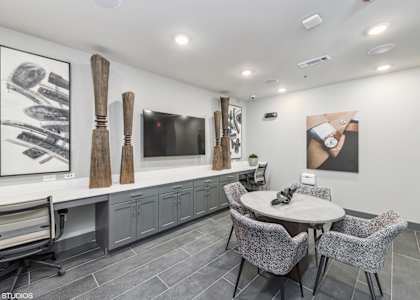 A modern dining room with a grey table and chairs.