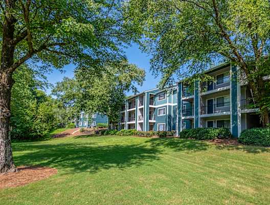 an apartment building with green grass and trees