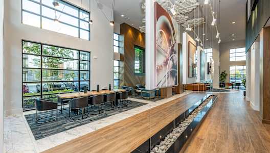 a large lobby with tables and chairs and a water feature at 19 South Apartments in Kissimmee, FL