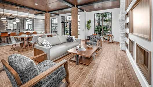 a living room with couches and chairs and a dining room with tables at The Haven at Lake Britt Apartments, Winter Garden, FL 34787