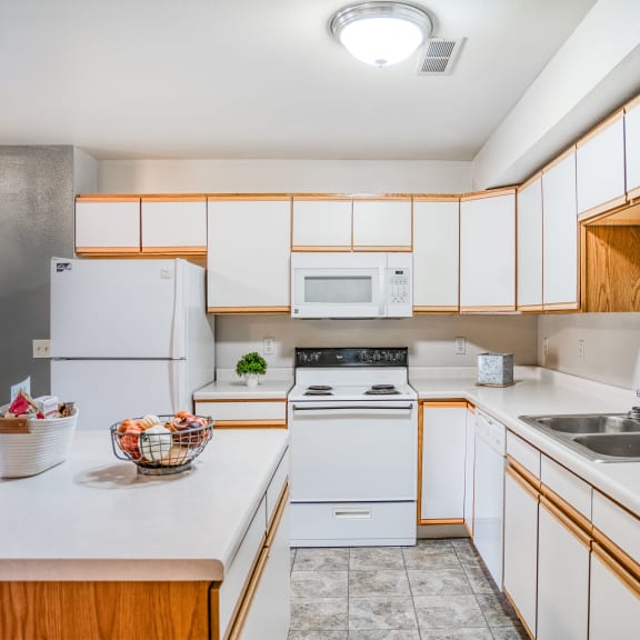 a kitchen with white appliances and wooden cabinets