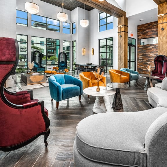 a lounge area with chairs and tables and windows