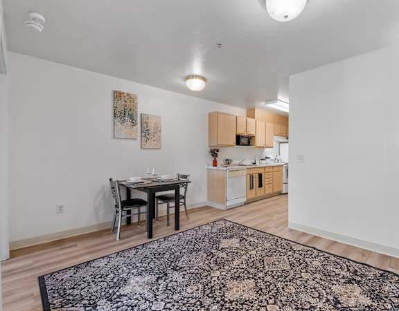 a living room with a dining room table and a kitchen
