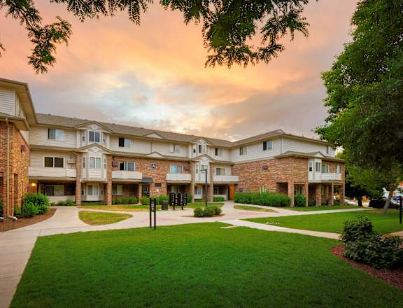 Apartment complex with a grassy area in front.