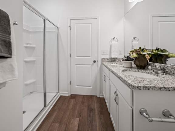 A bathroom with a white door and a marble counter.