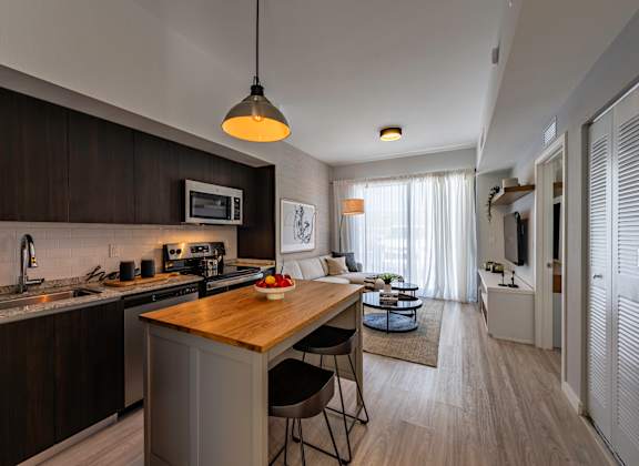 A modern kitchen with dark wood cabinets and a wooden island.