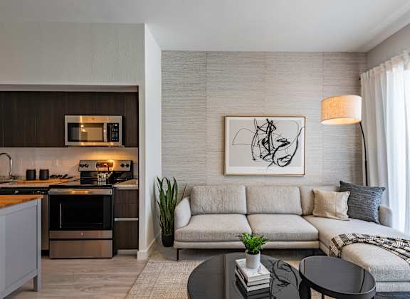 A modern living room with a grey sofa and a black coffee table.